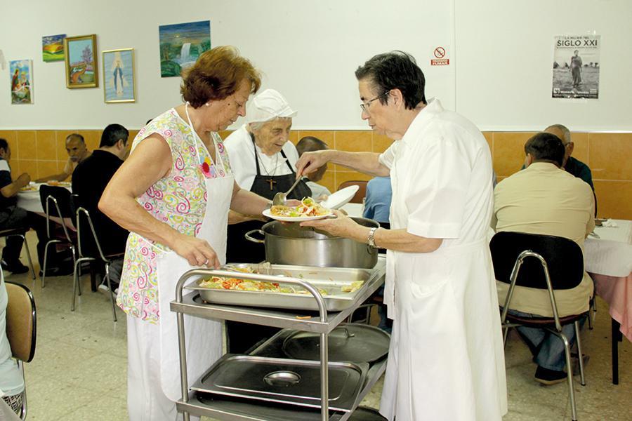 Luisa, voluntaria seglar; Isabel, hermanita de Foucauld y voluntaria; y Sor Nieves, hija de la Caridad; sirviendo la comida en el comedor Santa Teresa