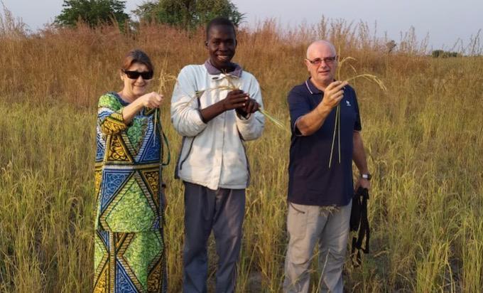 Mª Carmen y Pepe, en compañía de un antiguo alumno del centro Charles Lwanga, con su primera cosecha de trigo