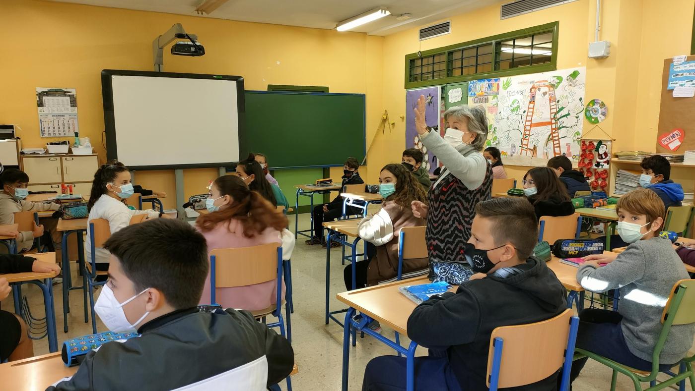 Mons. Catalá muestra la placa que le ha regalado el centro