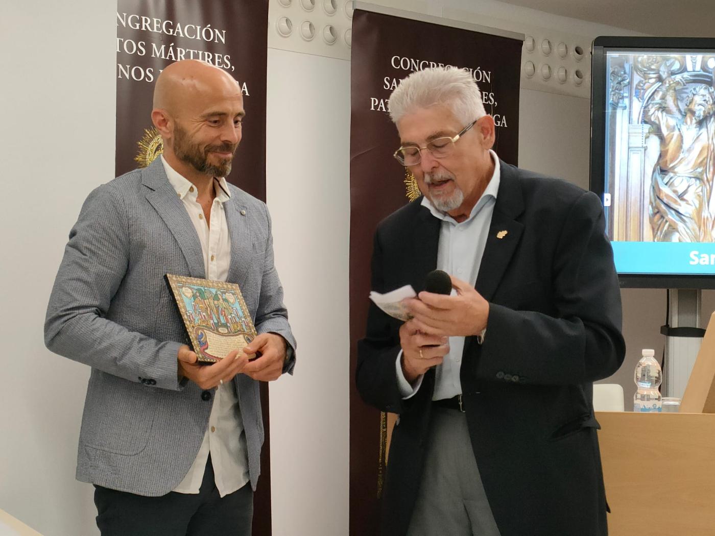 Ángel Nuño recibe un exvoto de los santos patronos de manos del Hermano Mayor, Antonio Ortega / A. MEDINA