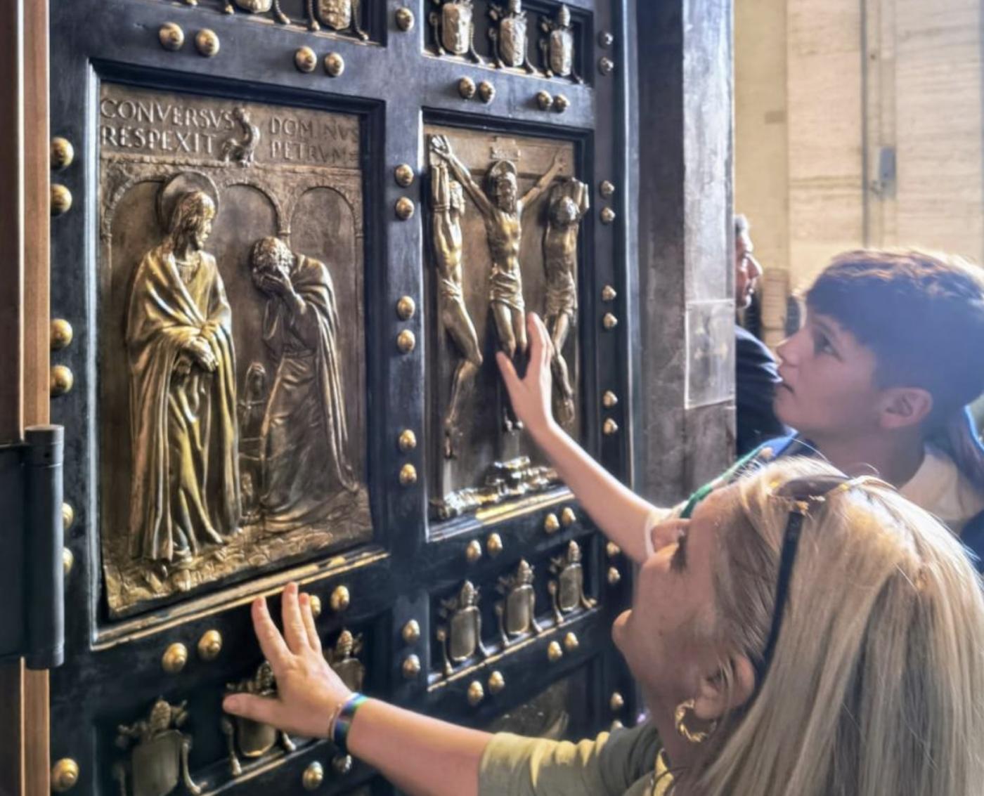 Natalia y el hijo de Lydia admiran las imágenes que ilustran la Puerta Santa de San Pedro